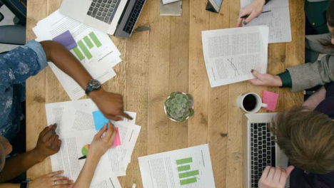 Overhead-View-Of-Male-And-Female-Colleagues-Working-Together-At-Desk